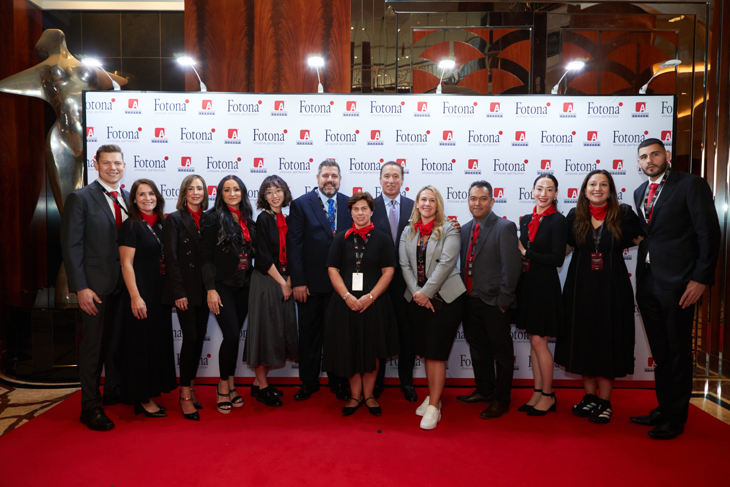 team photo-min Fotona team group photo on red carpet with branded backdrop during official conference event reception