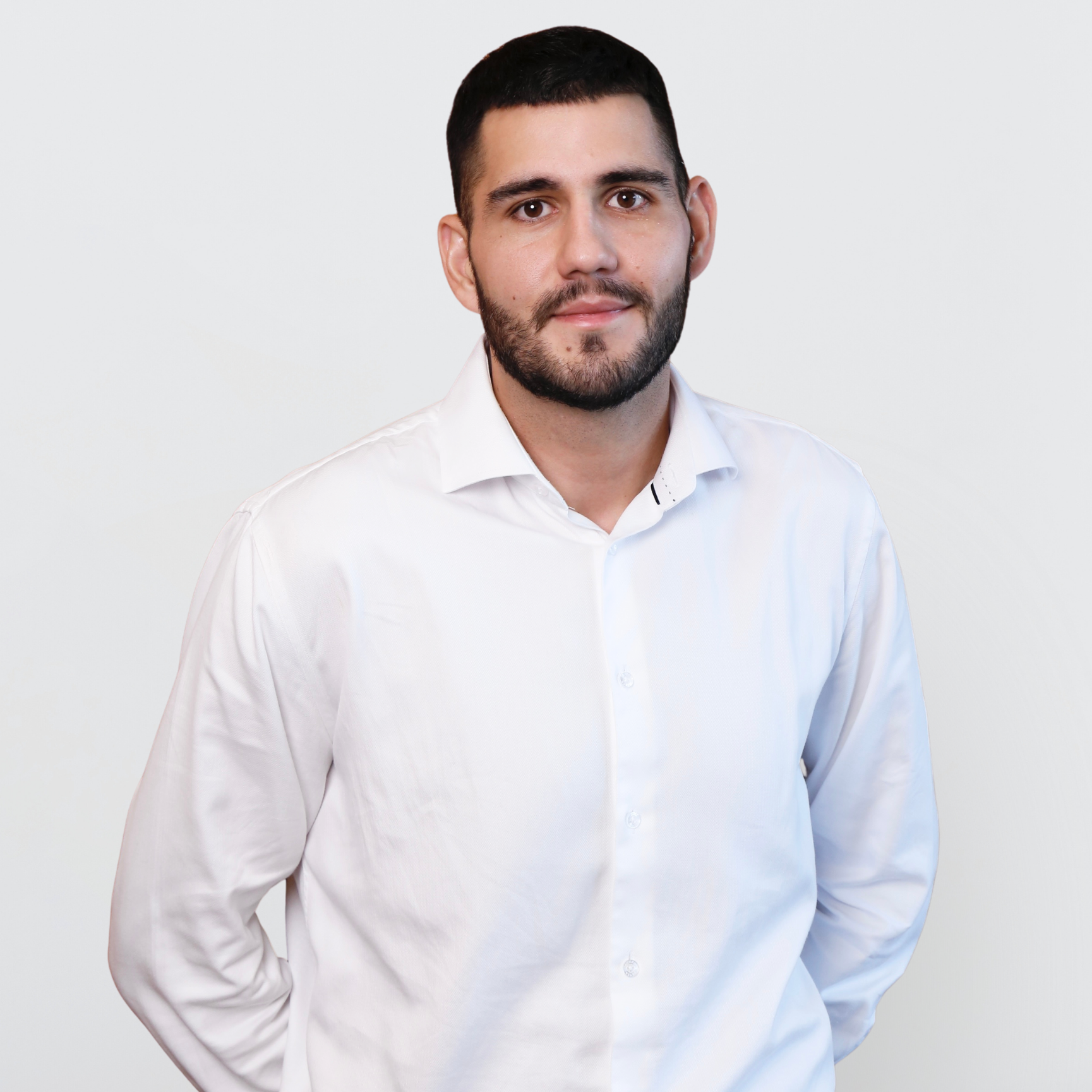 Professional headshot of male healthcare executive wearing white shirt against neutral studio background